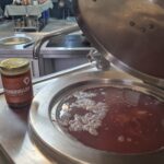 Pot met bottenbouillon en groenten in een professionele keuken.